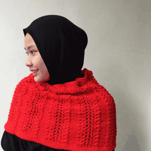 A young woman wearing the Plumed cowl as a cape.To