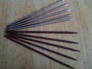 A selection of knitting needles with a square profile.